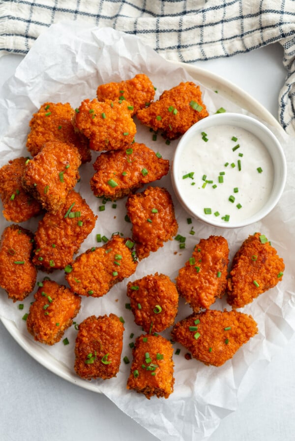 buffalo tempeh served on a large white serving plate with dipping sauce