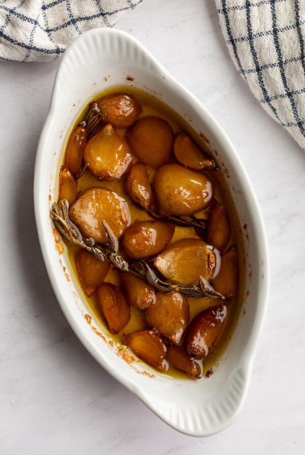 Cooked garlic in a white dish.