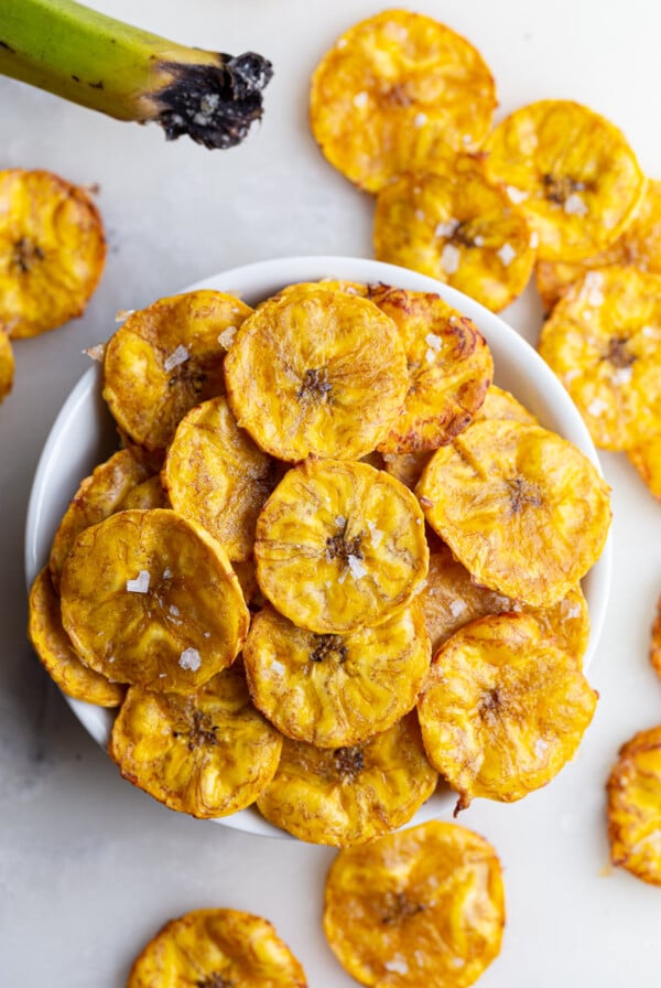 Plantain chips served in a small white bowl.