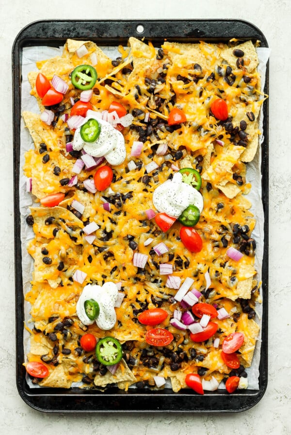 Vegetarian Nachos topped with sour cream, peppers and tomatoes.
